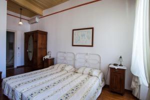 a bedroom with a bed with a white bedspread at Nostos Guesthouse in Kythira
