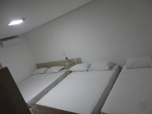 two beds sitting next to each other in a room at Hotel Bela Vista Votorantim in Votorantim
