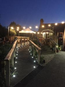 a wooden walkway with lights on it at night at Helen Browning's Royal Oak in Swindon