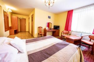 ワルシャワにあるHotel Waldのベッドとデスクが備わるホテルルームです。