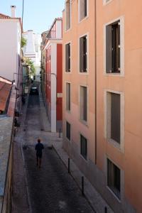 リスボンにあるPrincipe Real Studio in Quiet Streetの二棟の間を歩く男