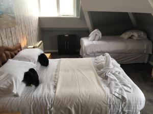 a hotel room with two beds with towels on them at Apartment 4, Cornerhouse Apartments in Llandudno