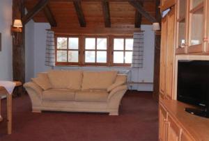 a living room with a couch and a television at ferienwohnungen hottenroth in Warmensteinach