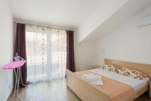 - une chambre avec un lit et une grande fenêtre dans l'établissement Apartments Budva Center 2, à Budva