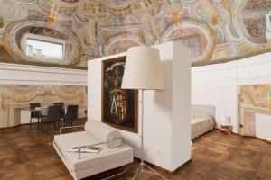 a room with a bed and a table with a lamp at Cupola Rubatti Tornaforte: Apollo e le sue Muse in Cuneo