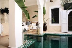 ein Wohnzimmer mit einem Pool in einem Haus in der Unterkunft Riad SHIRAZ in Marrakesch