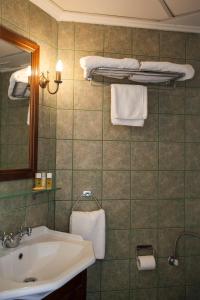 bagno con lavandino, specchio e asciugamani di Nostos Guesthouse a Citèra (Kýthira)