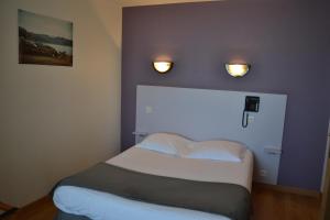 a bed in a room with two lights on the wall at Hôtel La Porte Saint Pierre-Logis Hôtel Intra Muros in Saint Malo