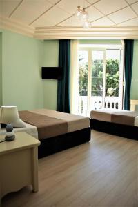 sypialnia z 2 łóżkami i dużym oknem w obiekcie Hotel Veliera w Durrës
