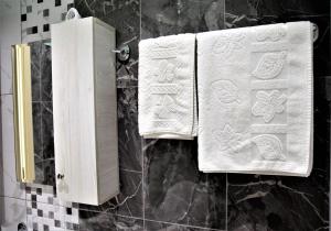 duas toalhas estão penduradas numa parede numa casa de banho em Hotel Veliera em Durrës