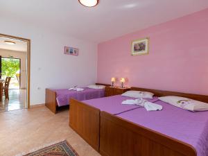 - une chambre avec 2 lits et des draps violets dans l'établissement Apartments Alice Green Oasis -, à Poreč