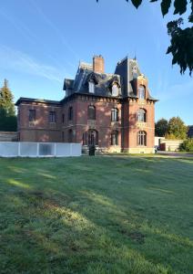 an old castle with a grass field in front of it at Chateau Gruchet Le Valasse in Gruchet-le-Valasse