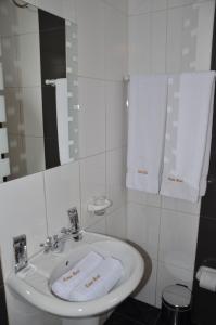 y baño con lavabo, espejo y toallas. en Casa Real Hoteles, en Cusco