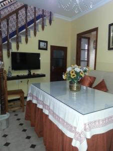 a living room with a table with a vase of flowers on it at Casa Rural La Verdura in Ubrique