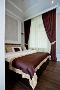 een slaapkamer met een groot bed met rode gordijnen bij Boutique Hotel Leningrad in Sint-Petersburg