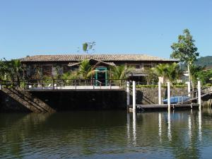 una casa en un muelle sobre un cuerpo de agua en Pousada Águas de Parati, en Paraty