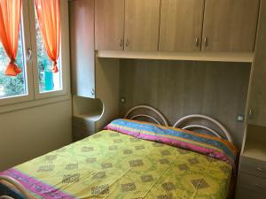 1 dormitorio con 1 cama con edredón en Villa Ca' Claudia, en Rosolina Mare