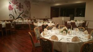 a dining room with tables and chairs with white table settings at Hosser's Hotel Restaurant in Idar-Oberstein