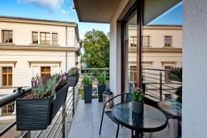 Un balcón con una mesa y sillas y un edificio. en Kopernika8 Miro Apartment with Balcony and AC, en Cracovia