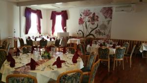 a dining room with tables and chairs with red bows at Hosser's Hotel Restaurant in Idar-Oberstein