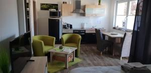 ハインスベルクにあるFerienwohnung Anke - Apartment 3の小さなキッチン(緑の椅子、テーブル付)