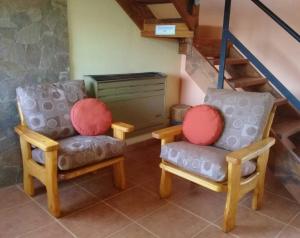 2 sillas en una habitación con escalera en La Ribera - Sepúlveda 191 en El Chaltén