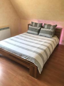 1 dormitorio con 1 cama grande con sábanas y almohadas a rayas en Chez Dina en Lutzelhouse
