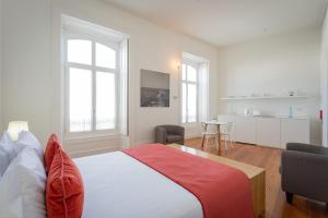 a bedroom with a large bed and a kitchen at AC-Armazéns Cogumbreiro in Ponta Delgada