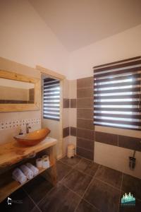 baño con lavabo de madera y ventana en Retreat Margau Apuseni-Adults Only- wellness & wellbeing, en Mărgău