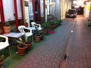 a street with chairs and tables and potted plants at Hotel Necmi in Samsun