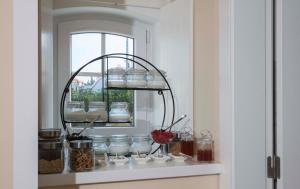 a shelf in a kitchen with jars and a window at Chalet O Amorzinho Sintra Praia in Sintra