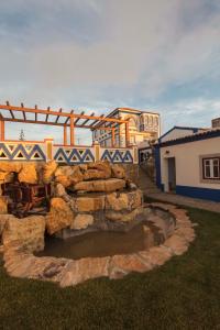 a stone bridge over a pond in a yard at Chalet O Amorzinho Sintra Praia in Sintra
