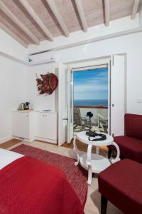 a bedroom with a bed and a table and a view of the ocean at Chalet O Amorzinho Sintra Praia in Sintra