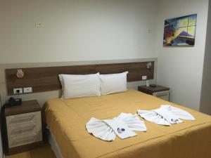 Un dormitorio con una cama con toallas blancas. en Elite Palace Hotel, en Prudentópolis