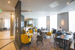 a restaurant with tables and chairs and people sitting at tables at Maldron Hotel Newcastle in Newcastle upon Tyne