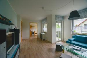 a living room with a blue couch and a table at Ferienwohnung am großen Stein in Leutersdorf +4 photos