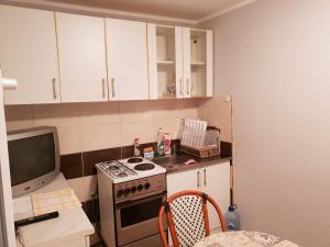 uma pequena cozinha com fogão e televisão em Apartment Miki em Herceg Novi