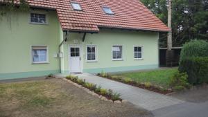 una piccola casa verde con tetto rosso di Ferienwohnung am großen Stein a Leutersdorf