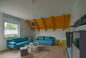 a living room with blue couches and a tv at Ferienwohnung am großen Stein in Leutersdorf