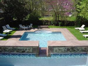 a swimming pool with a fountain in a yard at Hôtel des Pyrénées in Saint-Jean-Pied-de-Port