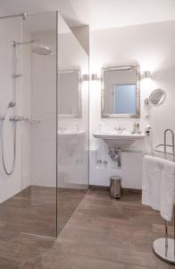 bagno con doccia in vetro e lavandino di Hotel Miramar a Westerland