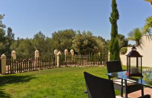 una mesa y sillas en un patio con una valla en Montemares Golf Luxury Villas & Apartments at La Manga Club, en La Manga del Mar Menor