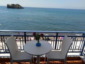 a table and chairs on a balcony overlooking the beach at Hotel Kyma in Skala Eresou