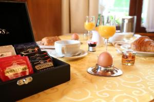 a table topped with a table with eggs and wine glasses at Le Robinson in Mézières-sur-Oise