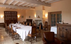 a dining room with a table and chairs and a fireplace at Hôtel des Pyrénées in Saint-Jean-Pied-de-Port