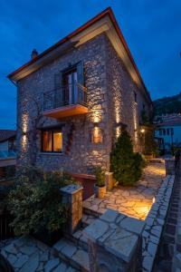 una casa de piedra con luces en el lateral. en Ontas Guesthouse & Spa, en Arachova