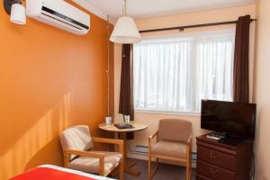 a room with a bed and a tv and a table at Hotel Robin Hood in Grand Falls