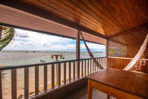 莫羅聖保羅的住宿－Amendoeira Praia Hotel，一个带吊床的门廊,享有海滩美景