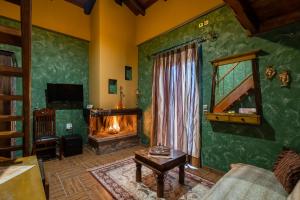 a living room with a fireplace and a couch at Ξενώνας Οντάς & Spa in Arachova