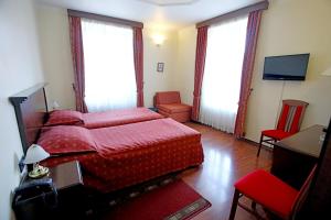a bedroom with a red bed and a television at Hotel Lavica in Samobor